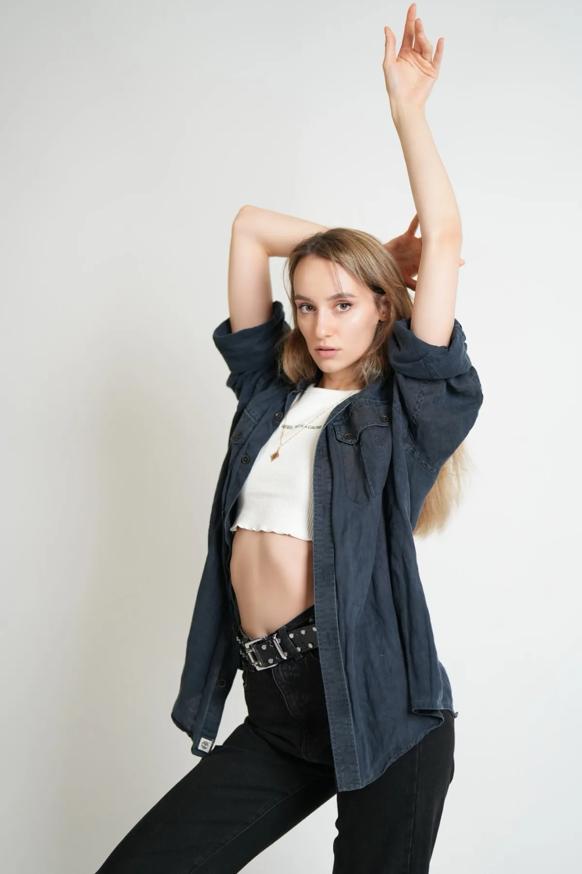 Editorial fashion photograph with dynamic movement, styled against a plain studio background